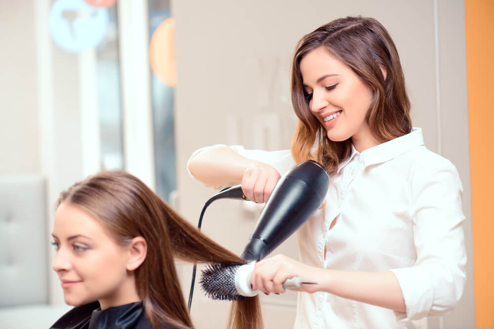 stylist talking to client in salon chair